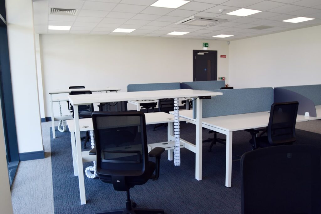 Modern coworking research and development office space at FMCI with ergonomic chairs, height-adjustable desks, and partitioned workstations. The open-plan layout offers a bright, professional environment for tech startups, mobility innovators, and businesses looking for flexible office rentals in Shannon, Ireland.