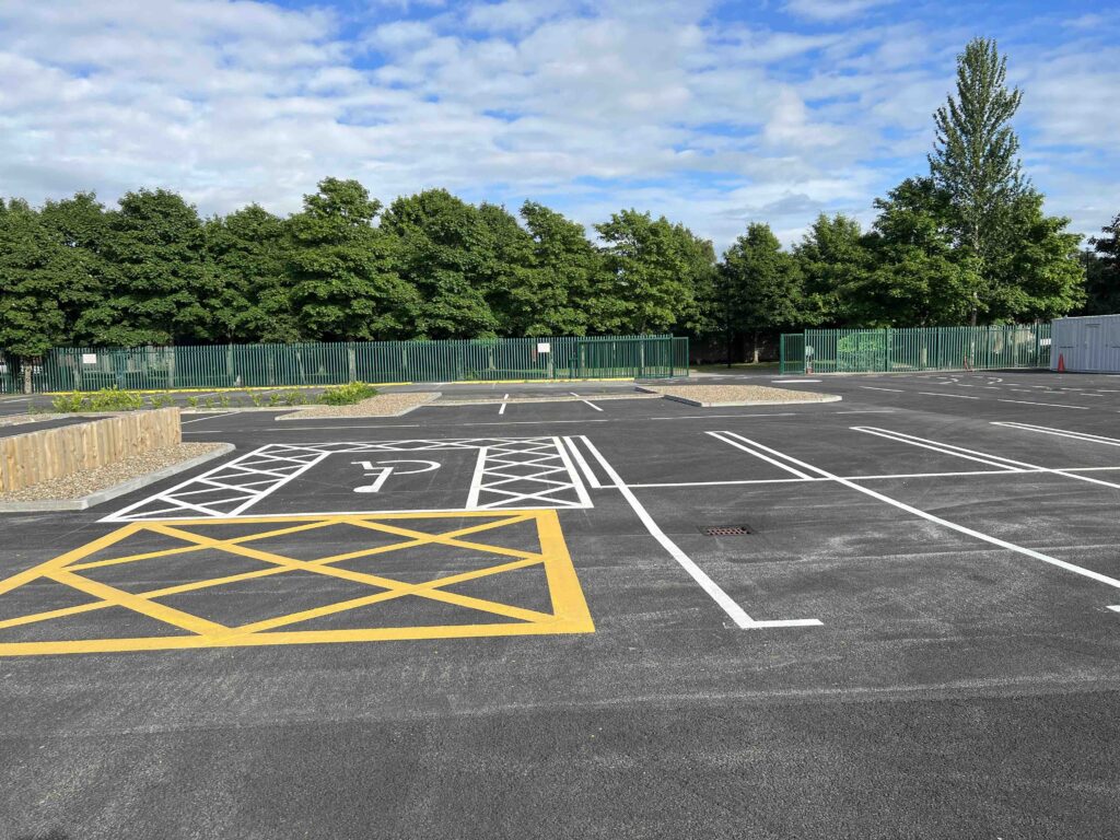 Autonomous vehicle and connected transport testing area at Future Mobility Campus Ireland, featuring clearly marked spaces, designated charging zones, and smart mobility infrastructure with a secure fenced perimeter and green surroundings.