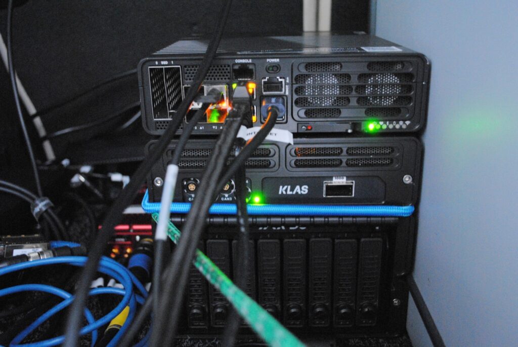 Close-up of KLAS edge computing unit integrated into an FMCI test vehicle for real-time data processing and mobile connectivity, supporting advanced autonomous vehicle testing infrastructure.