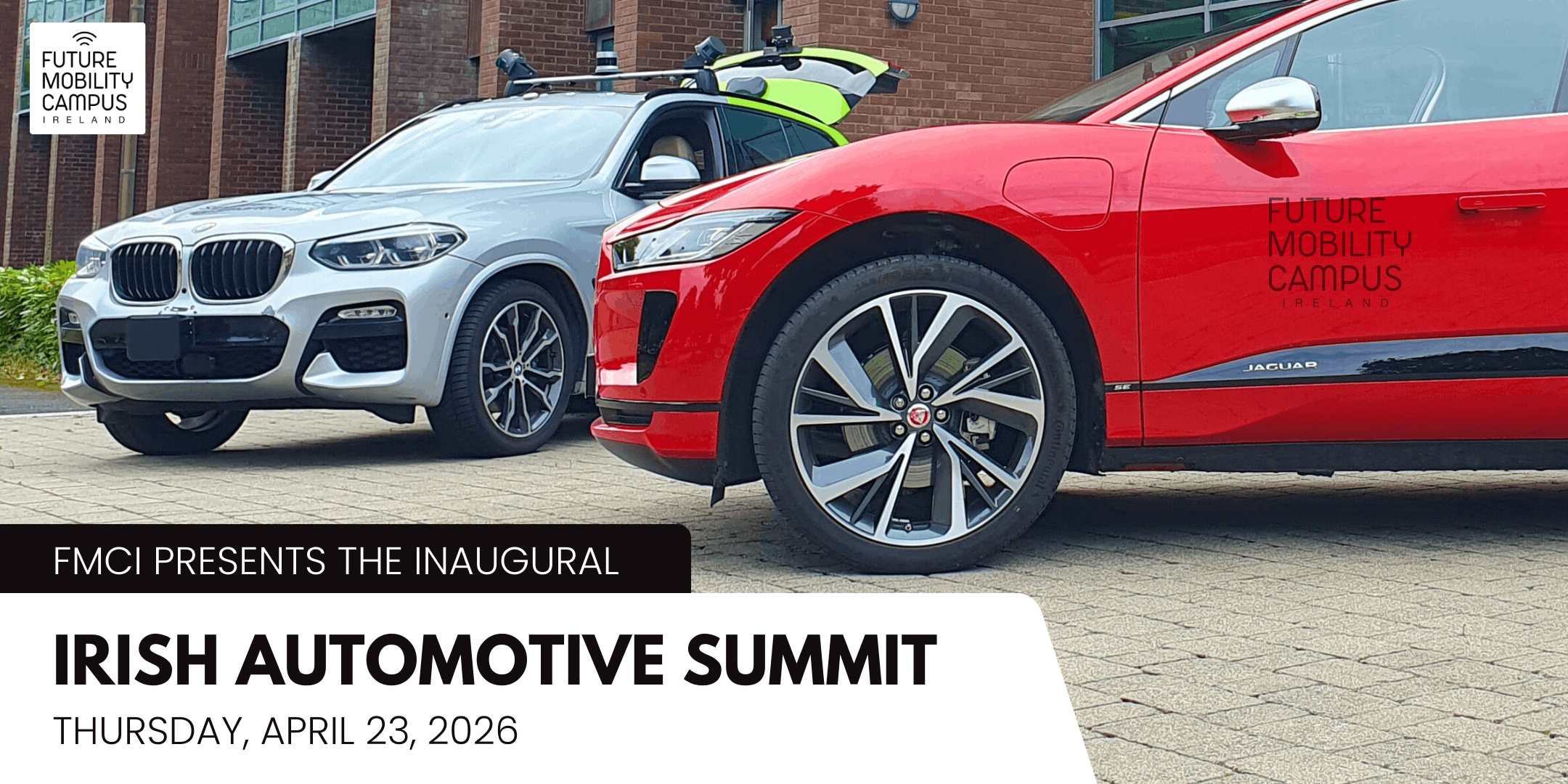 Banner image for the Irish Automotive Summit. The photo shows two cars, a red Jaguar iPace and a silver BMW X3, in front of a brick building. The BMW is fitted with sensors on the roof rack. The image is overlaid with text that reads "FMCI presents the inaugural Irish Automotive Summit, Thursday, April 23, 2026."